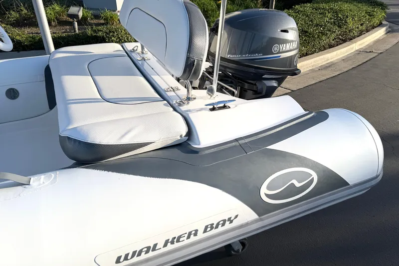 Slide: The Image of 2021 Walker Bay Generation 10 LTE boat with Yamaha outboard motor, docked on pavement. - 2