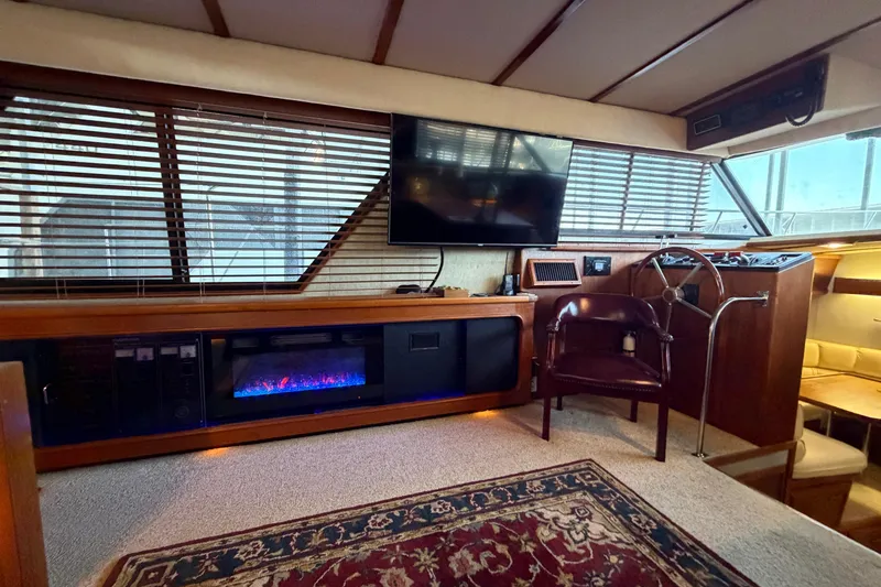 Slide: The Image of 1987 Carver 4207 Aft Cabin Motor Yacht interior with fireplace, TV, and steering wheel. - 27