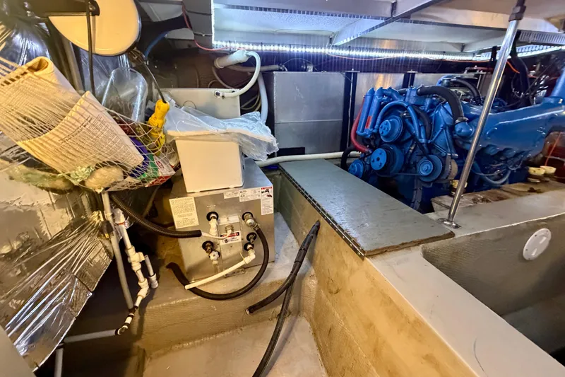 Slide: The Image of Engine room of 1987 Carver 4207 Aft Cabin Motor Yacht, featuring blue engine and equipment. - 52