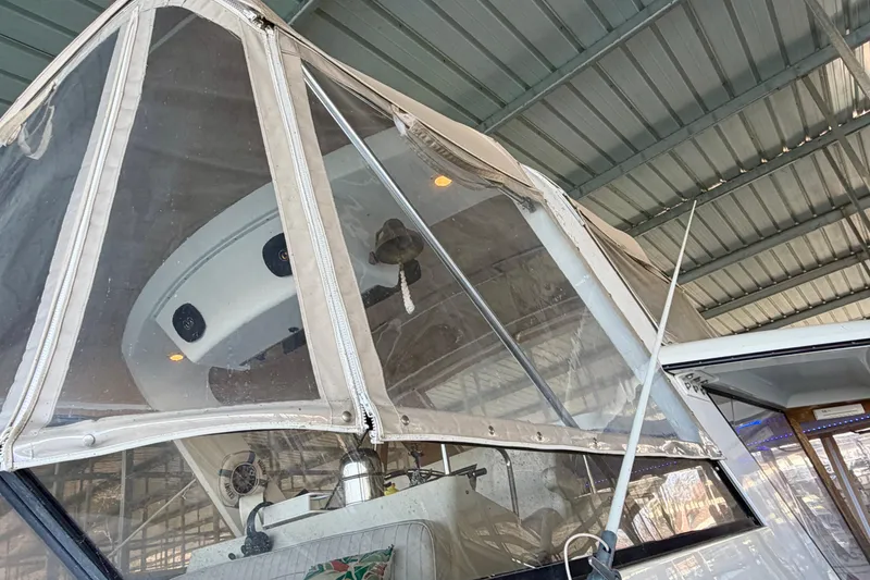 Slide: The Image of 1987 Carver 4207 Aft Cabin Motor Yacht under a metal roof, featuring clear enclosure. - 9