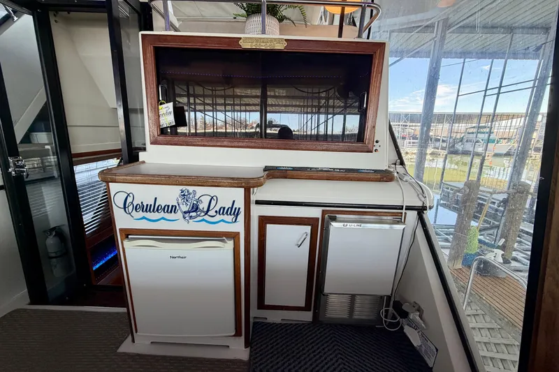 Slide: The Image of 1987 Carver 4207 Aft Cabin Motor Yacht interior with kitchenette and marina view. - 12