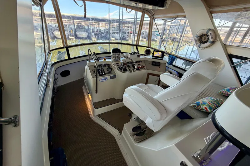 Slide: The Image of 1987 Carver 4207 Aft Cabin Motor Yacht helm with white captain's chair and navigation equipment. - 17