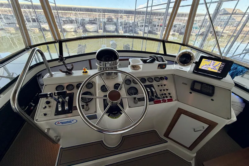 Slide: The Image of 1987 Carver 4207 Aft Cabin Motor Yacht helm with steering wheel and navigation equipment. - 18