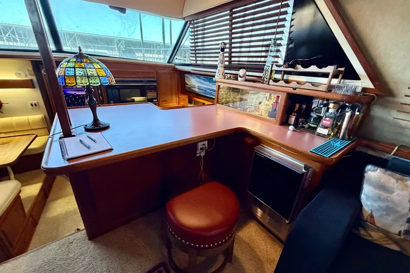 Slide: The Image of 1987 Carver 4207 Aft Cabin Motor Yacht interior with bar, stained glass lamp, and seating area. - 26