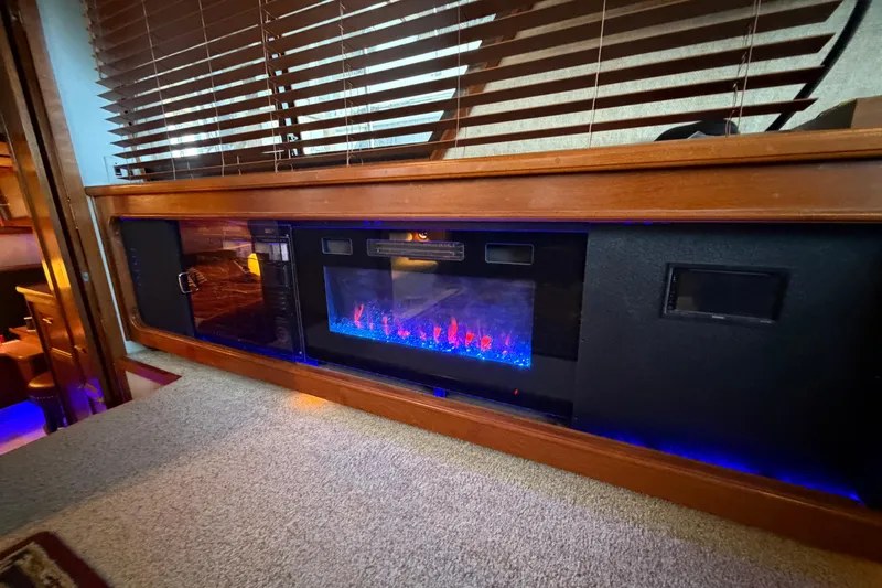 Slide: The Image of 1987 Carver 4207 Aft Cabin Motor Yacht interior with modern electric fireplace and wood accents. - 28