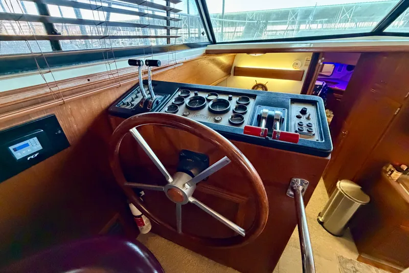 Slide: The Image of 1987 Carver 4207 Aft Cabin Motor Yacht helm with wooden steering wheel and control panel. - 29