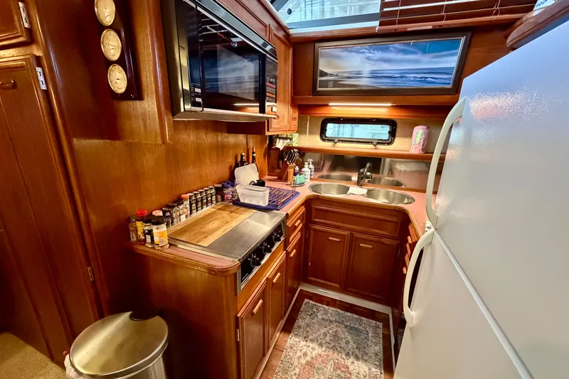 Slide: The Image of 1987 Carver 4207 Aft Cabin Motor Yacht kitchen with wooden cabinetry and modern appliances. - 33