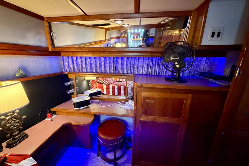 Slide: The Image of 1987 Carver 4207 Aft Cabin Motor Yacht interior with desk, fan, and ambient lighting. - 43