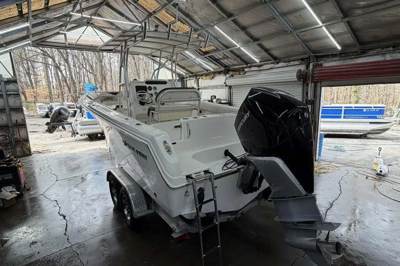 Slide: The Image of 2022 Sailfish 242 CC boat in a garage with outboard motor and trailer. - 10