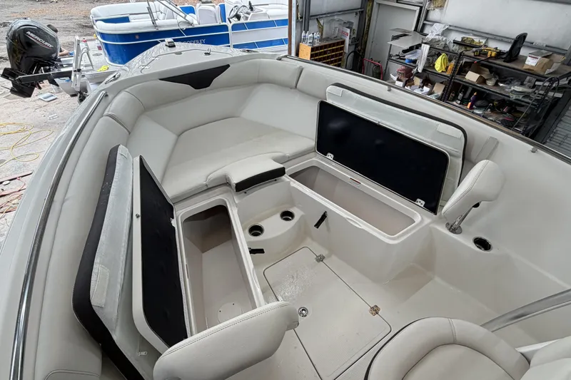 Slide: The Image of 2022 Sailfish 242 CC boat interior with open storage compartments in a workshop setting. - 13
