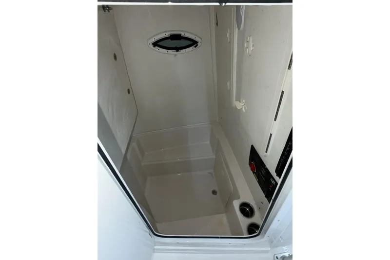 Slide: The Image of Interior of 2022 Sailfish 242 CC boat, featuring a compact, clean compartment with a small window. - 15