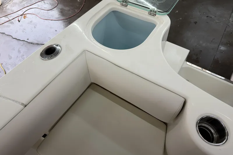 Slide: The Image of 2022 Sailfish 242 CC boat interior with cushioned seating and storage compartment. - 21