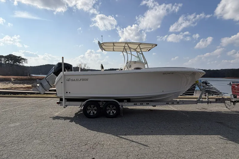 Slide: The Image of 2022 Sailfish 242 CC boat on trailer by a lake under a cloudy sky. - 5