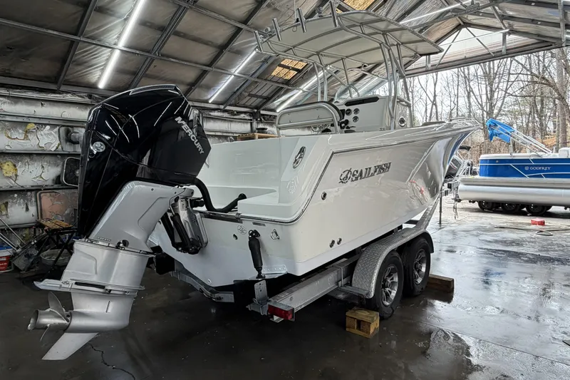 Slide: The Image of 2022 Sailfish 242 CC boat with Mercury engine in a garage setting. - 9