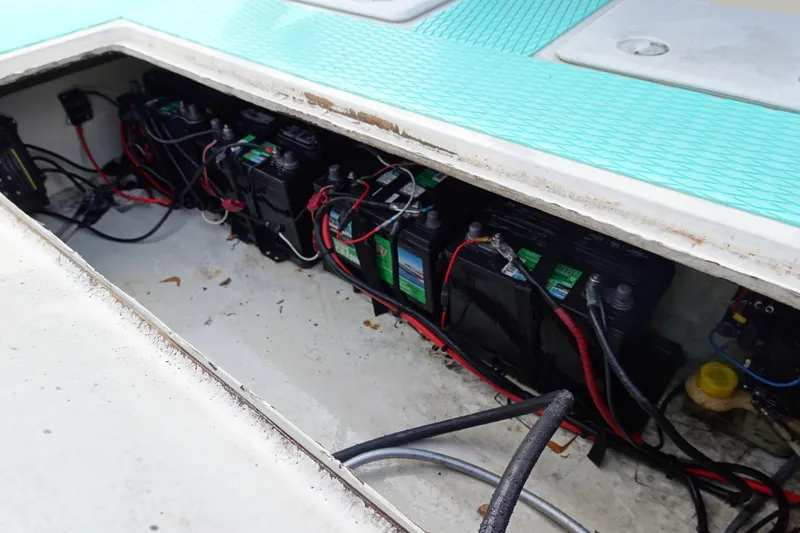 Slide: The Image of Battery compartment of a 1999 Stott Craft 1900 boat with multiple batteries and wiring. - 12