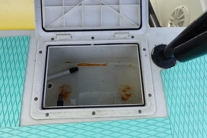 Slide: The Image of Open storage compartment on a 1999 Stott Craft 1900 boat, featuring turquoise padding. - 15