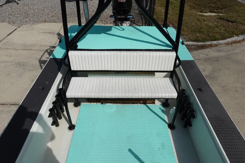 Slide: The Image of 1999 Stott Craft 1900 boat interior with teal flooring and white seating. - 16