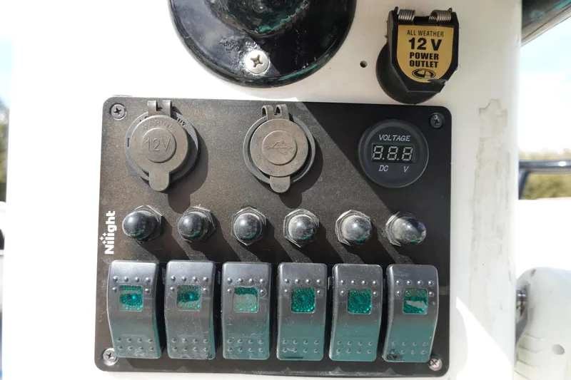 Slide: The Image of Control panel on a 1999 Stott Craft 1900 boat with 12V outlets and voltage display. - 18