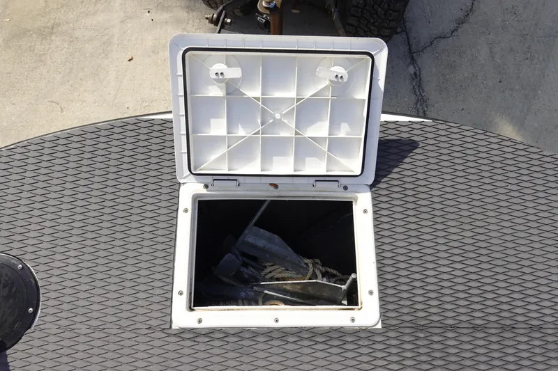 Slide: The Image of Open storage hatch on 1999 Stott Craft 1900 boat, showing interior with rope and anchor. - 21