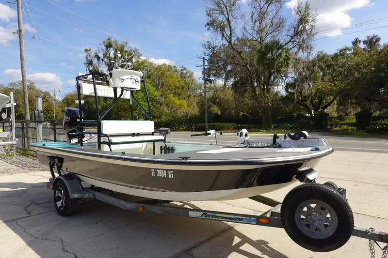 Slide: The Image of 1999 Stott Craft 1900 boat on trailer, parked outdoors under a clear sky. - 3