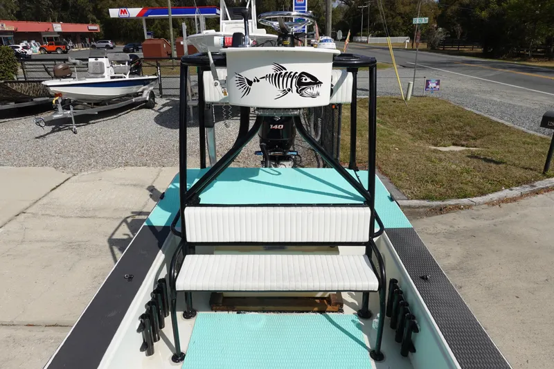 Slide: The Image of 1999 Stott Craft 1900 boat with fish graphic, parked near a gas station. - 7