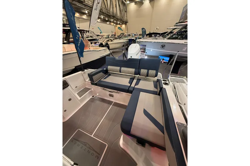 Slide: The Image of 2026 Monterey Elite 27 OB boat interior with luxurious seating at a boat show. - 13