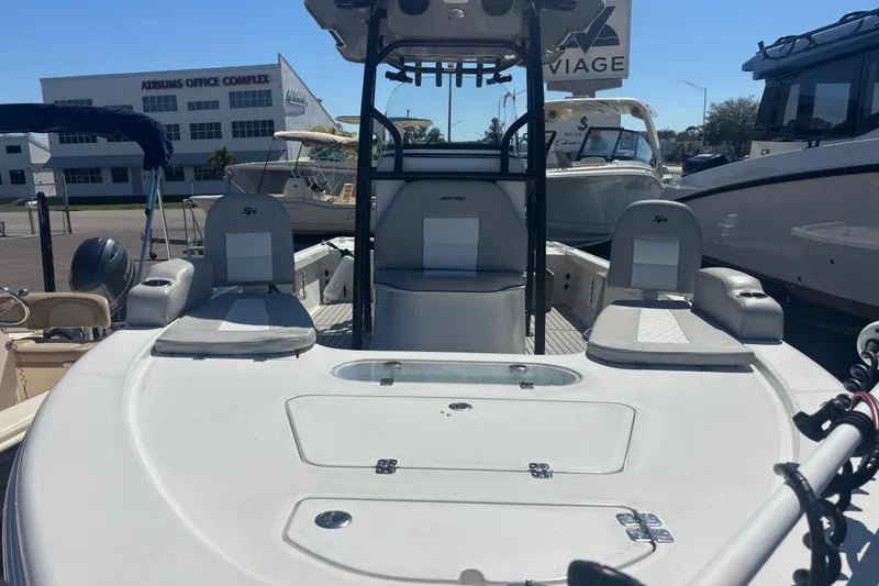 Slide: The Image of 2019 Sea Pro 248 Bay boat interior with seating and console, parked at a marina. - 8