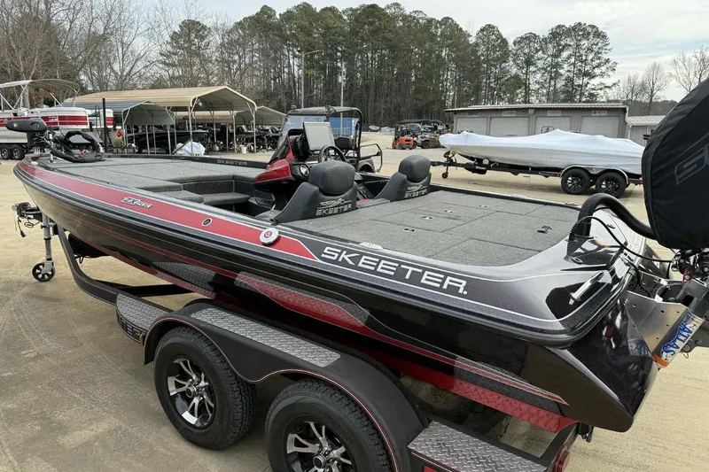 Slide: The Image of 2019 Skeeter ZX200 bass boat on trailer, parked outdoors near covered storage. - 7