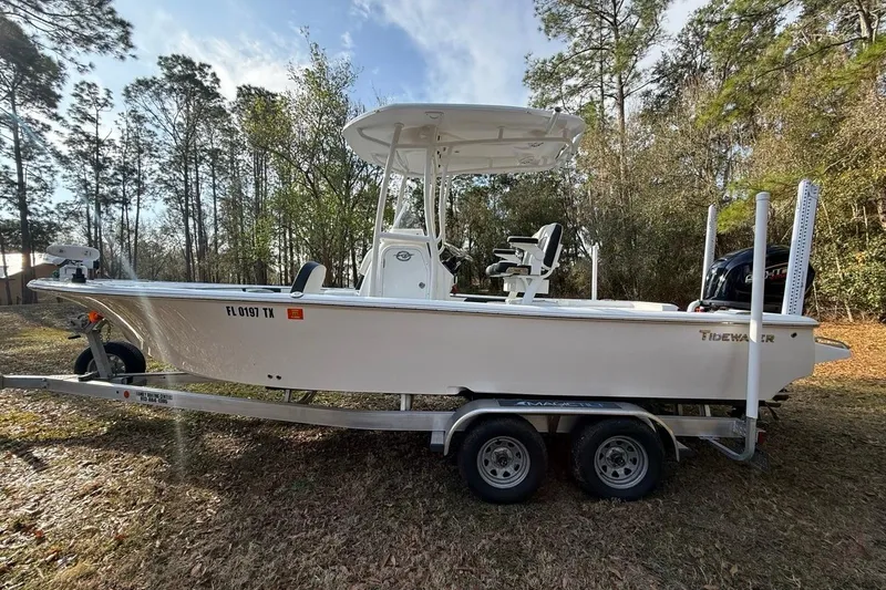 The Image of 2024 Tidewater 2300 Carolina Bay boat on trailer, surrounded by trees. - 1