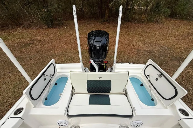 Slide: The Image of 2024 Tidewater 2300 Carolina Bay boat with open storage compartments and outboard motor. - 10