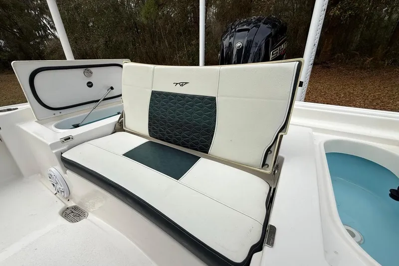 Slide: The Image of 2024 Tidewater 2300 Carolina Bay boat interior with cushioned seating and storage compartments. - 11
