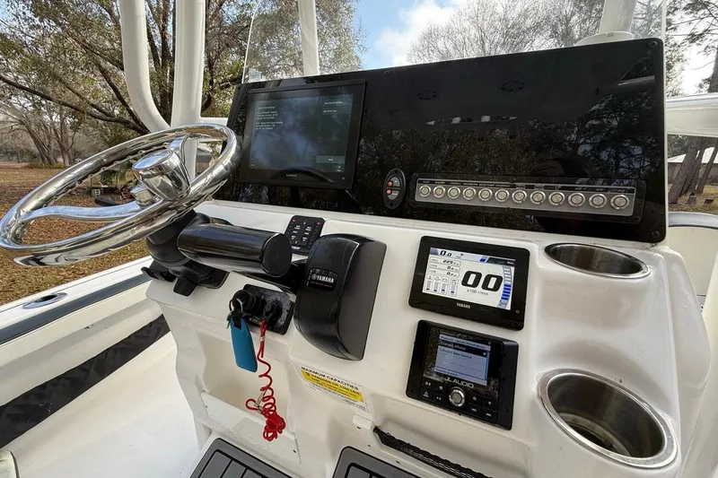 Slide: The Image of 2024 Tidewater 2300 Carolina Bay boat dashboard with steering wheel and electronic controls. - 20