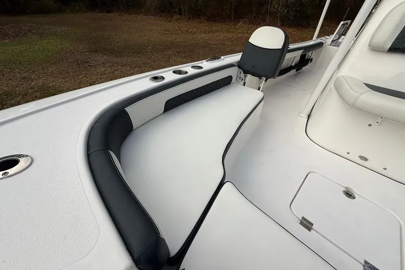 Slide: The Image of 2024 Tidewater 2300 Carolina Bay boat interior with cushioned seating and rod holders. - 29
