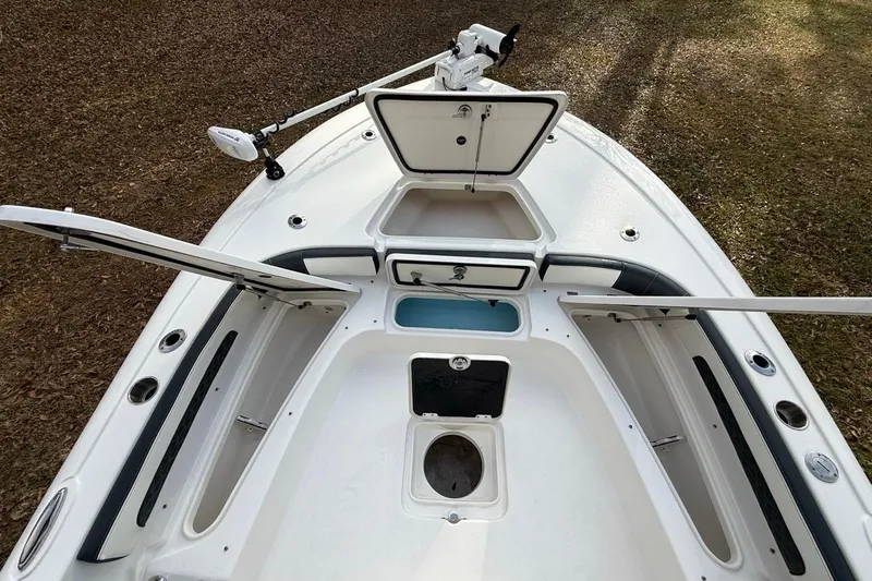 Slide: The Image of 2024 Tidewater 2300 Carolina Bay boat interior with open storage compartments and trolling motor. - 32