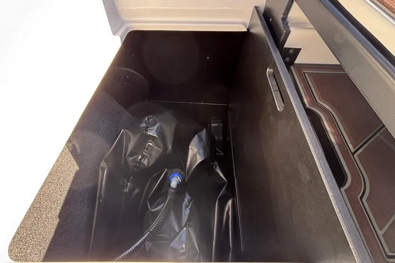 Slide: The Image of Storage compartment of 2026 Tigé Ultré 25ZX boat, featuring a ballast bag. - 23
