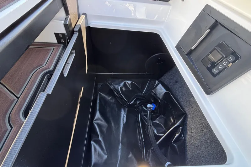 Slide: The Image of 2026 Tigé Ultré 25ZX storage compartment with control panel and black interior. - 24