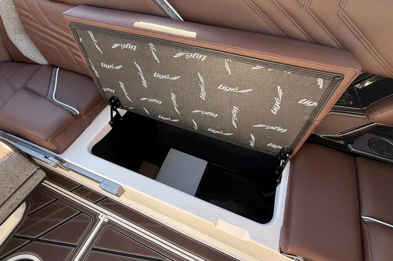 Slide: The Image of 2026 Tigé Ultré 25ZX boat interior storage compartment with brown leather seating. - 78