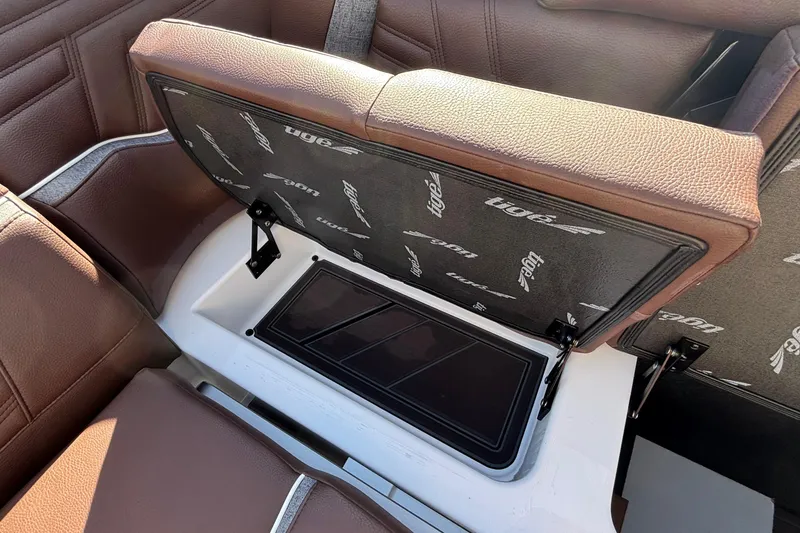 Slide: The Image of 2026 Tigé Ultré 25ZX boat seat storage compartment with brown upholstery. - 79