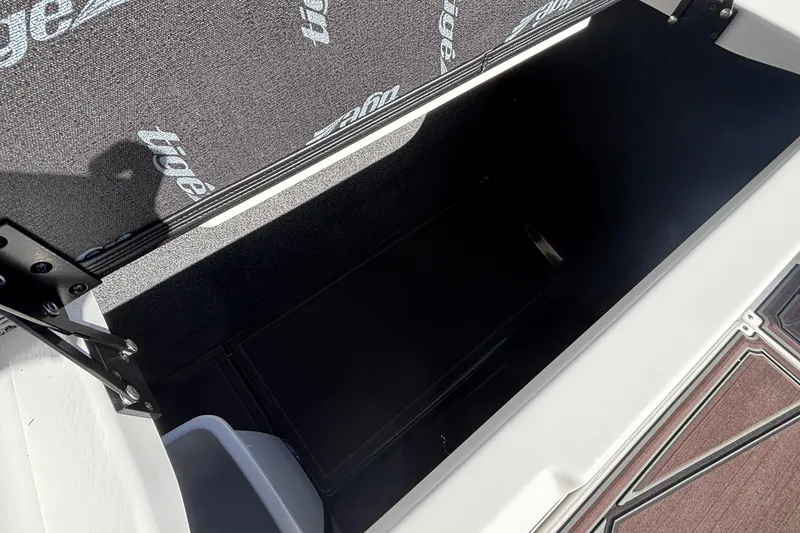 Slide: The Image of Open storage compartment in 2026 Tigé Ultré 25ZX boat, featuring branded interior lining. - 81