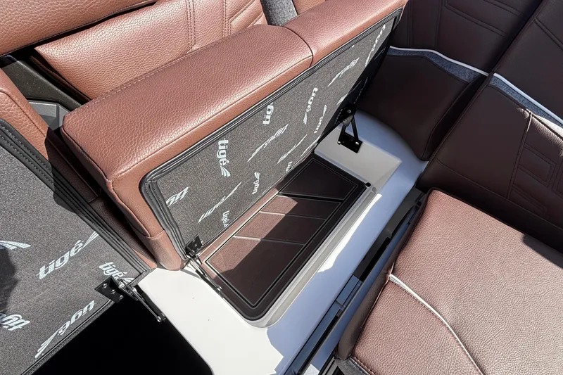 Slide: The Image of 2026 Tigé Ultré 25ZX boat interior with brown leather seats and storage compartment. - 82
