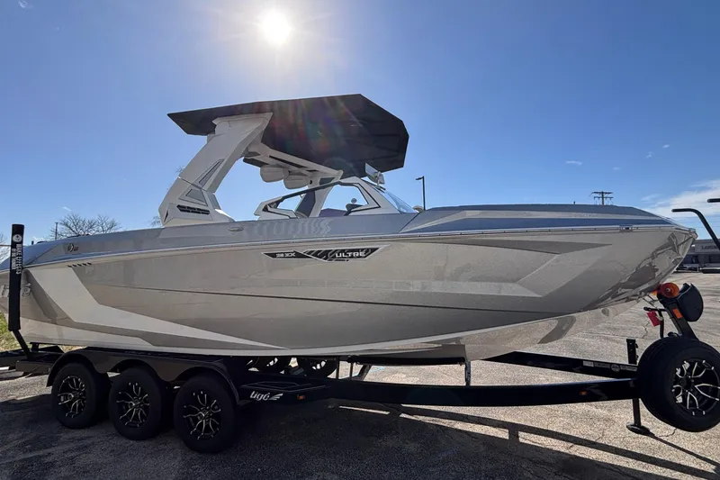 Slide: The Image of 2026 Tigé Ultré 25ZX boat on trailer under clear blue sky. - 89