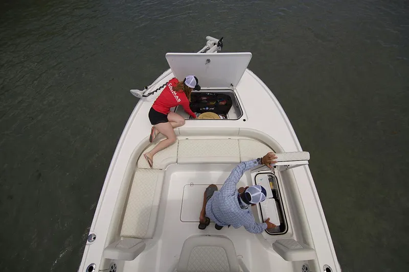 Slide: The Image of Manufacturer Provided Image: Two people accessing storage compartments on a 2026 Caymas 26 HB boat. - 6