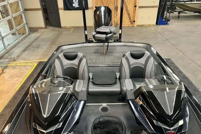Slide: The Image of 2018 Ranger Z520L boat interior with dual seats and sleek design in a showroom. - 10