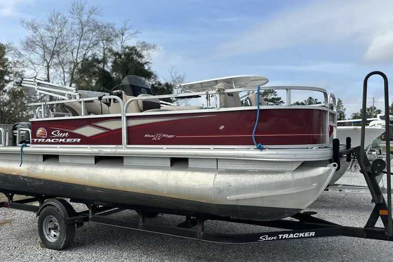 The Image of 2018 Sun Tracker Bass Buggy 18 DLX pontoon boat on trailer, red and silver design. - 0