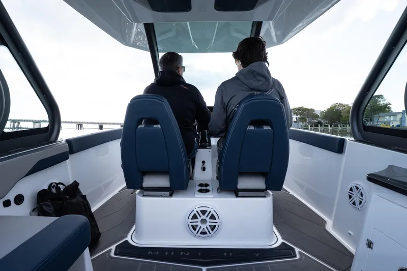 Slide: The Image of Two people seated on a 2026 Monterey Elite 27 OB boat, enjoying a scenic view. - 23