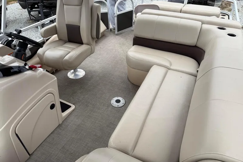 Slide: The Image of 2019 Sun Tracker Fishin' Barge 22 XP3 interior with beige seating and steering console. - 5