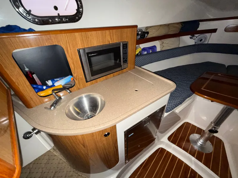 Slide: The Image of Interior of 2008 Pursuit OS 285 Offshore with kitchenette and seating area. - 12