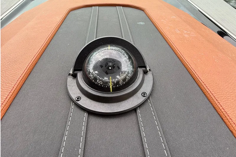 Slide: The Image of Compass on 2023 Cruisers Yachts 34 GLS OB dashboard, featuring stitched leather accents. - 7