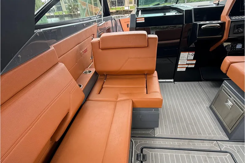 Slide: The Image of 2023 Cruisers Yachts 34 GLS OB interior with brown leather seating and modern dashboard. - 18