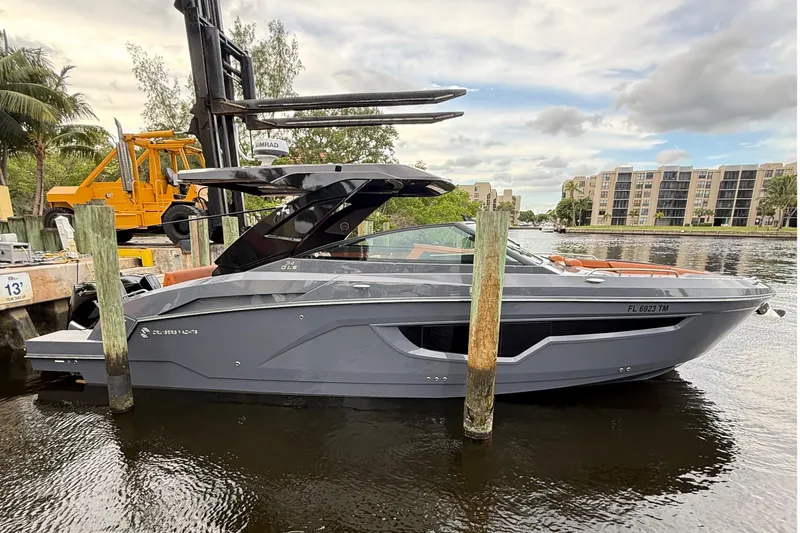 Slide: The Image of 2023 Cruisers Yachts 34 GLS OB docked by waterfront buildings. - 2